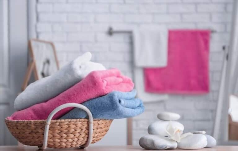 a basket with 3 light colored towels a basket with 3 light colored towels