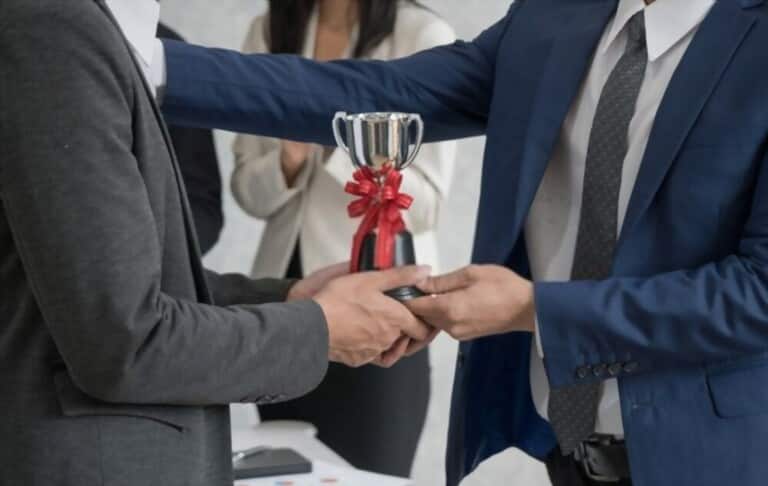 Image of a man giving a cup to his longtime colleague Image of a man giving a cup to his longtime colleague