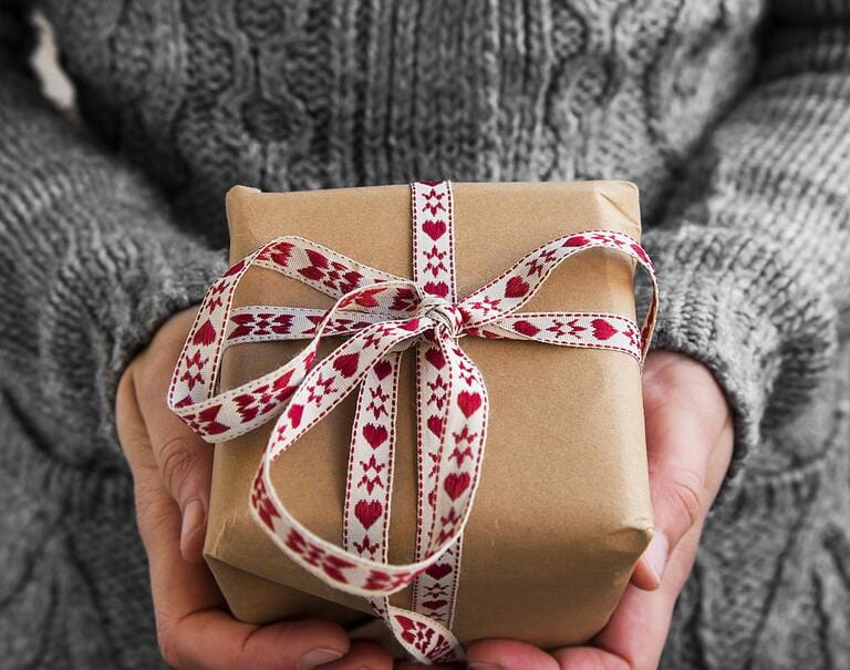 female hand holding a hand-wrapped gift box