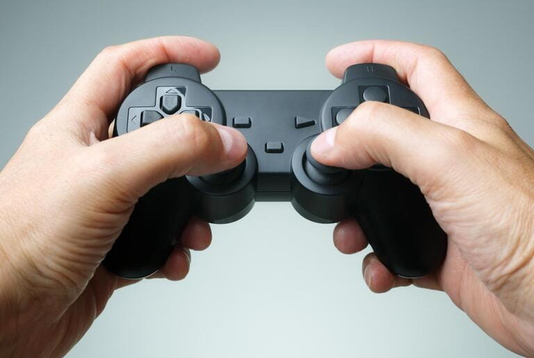 Video game console controller in gamer hands