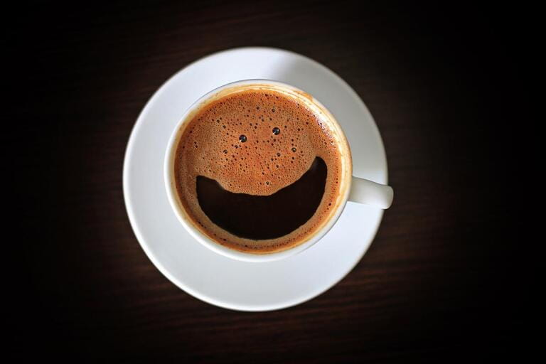 Smile coffee cup top view on dark background. Funny coffee drink. Smile coffee cup top view on dark background. Funny coffee drink.