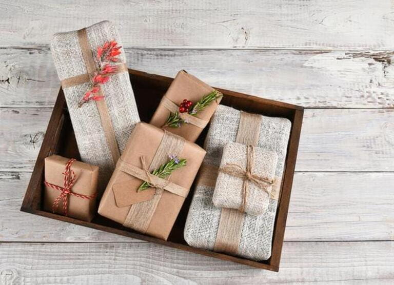 Christmas Presents. Burlap and plain brown paper wrapped gifts in a wood box