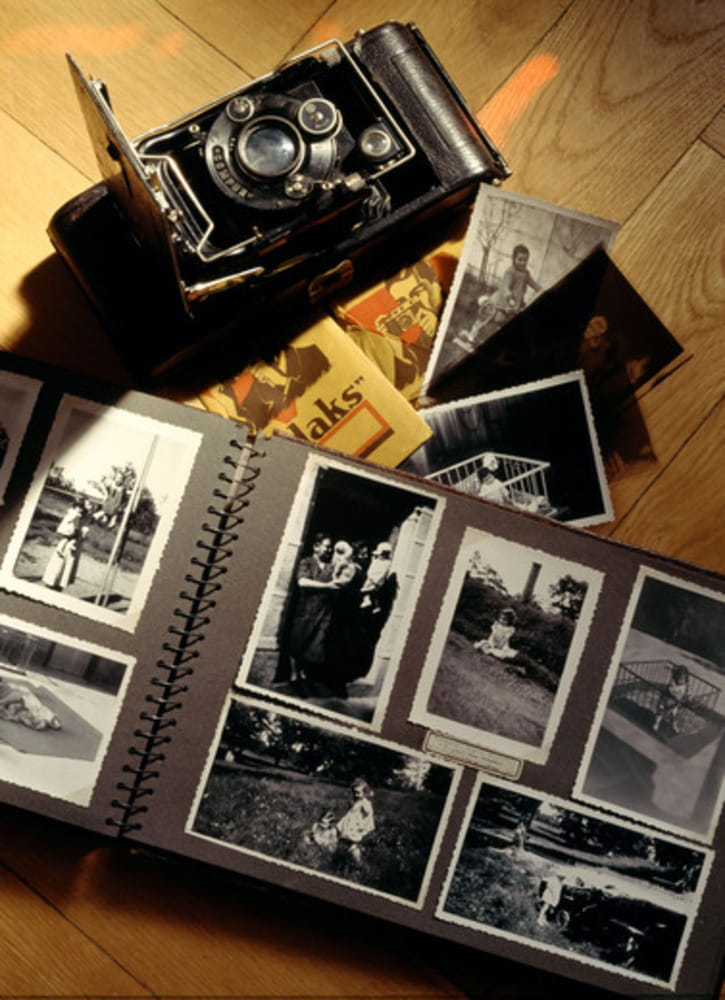 Ancient picture album with 1942 baby photos and old folding camera