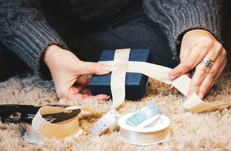 A person wrapping a gift A person wrapping a gift