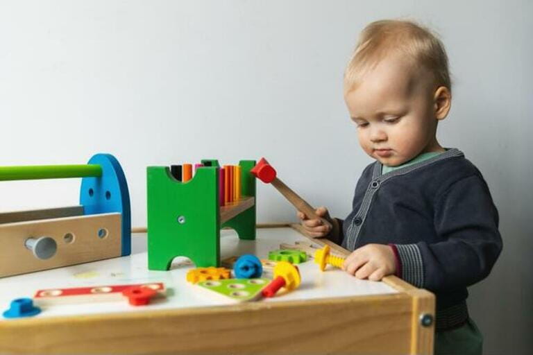 toddler boy playing with toy tool box at home toddler boy playing with toy tool box at home