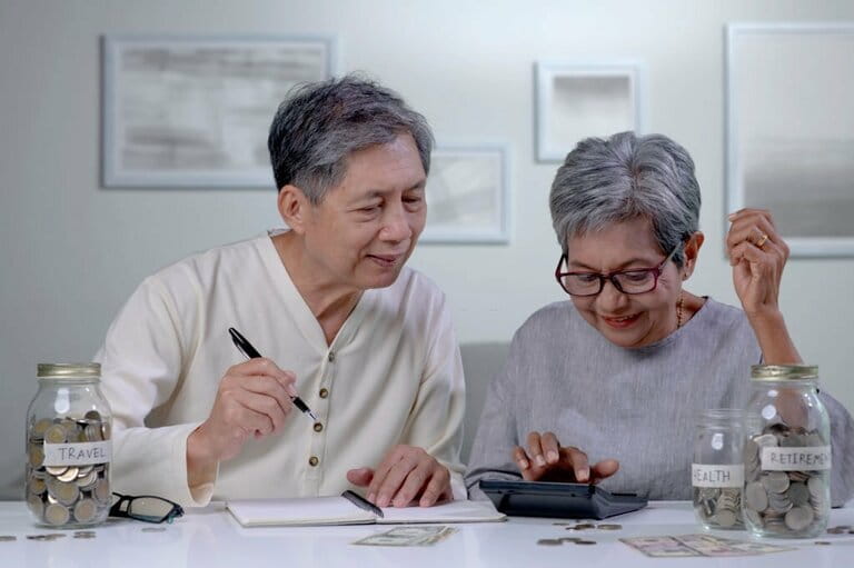Senior Asian couple plans to save money to spend after retirement Senior Asian couple plans to save money to spend after retirement