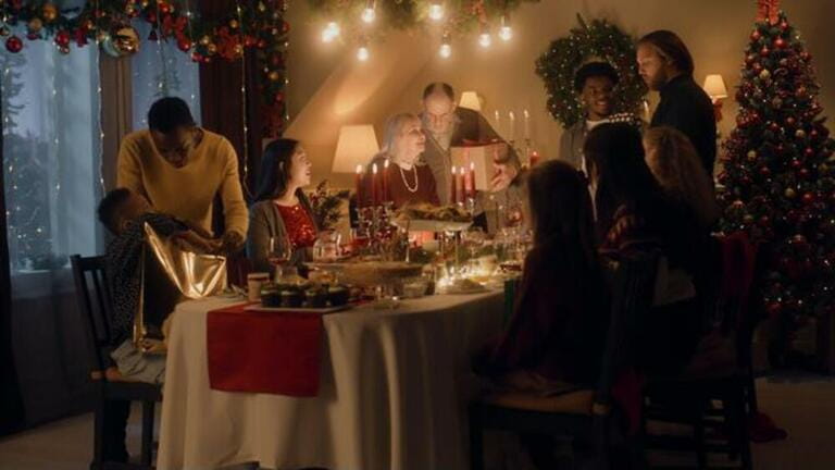 Happy multi cultural family celebrating Christmas or New Year 2023, exchanging gifts. Served holiday table with different dishes and candles. Warm atmosphere of family Christmas dinner at home. Happy multi cultural family celebrating Christmas or New Year 2023, exchanging gifts. Served holiday table with different dishes and candles. Warm atmosphere of family Christmas dinner at home.