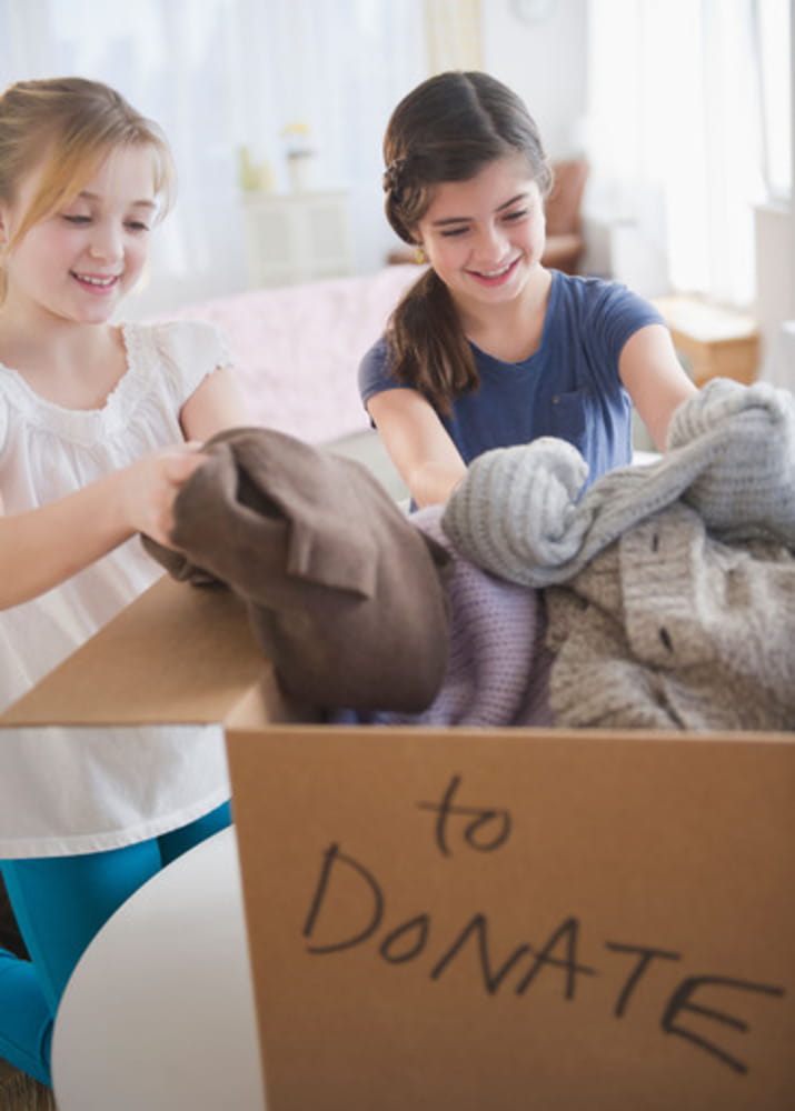 USA, New Jersey, Jersey City, Two girls packing clothing for donations USA, New Jersey, Jersey City, Two girls packing clothing for donations