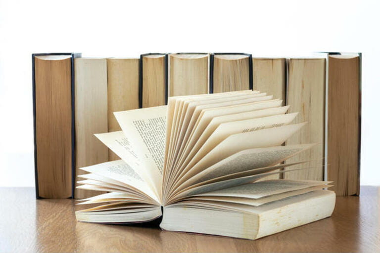 Row of old books open book at the front. Row of old books open book at the front.