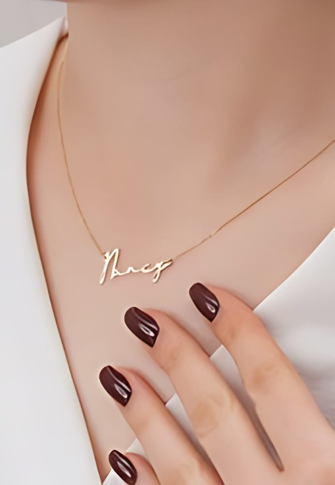 Silver necklace with "Nancy" inscription. Gold name necklace is on the neck of the woman in the white dress. Silver necklace image for e-commerce and online sales. Personalized gift image. Silver necklace with "Nancy" inscription. Gold name necklace is on the neck of the woman in the white dress. Silver necklace image for e-commerce and online sales. Personalized gift image.