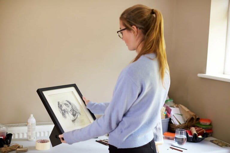Teenage female artist holding a painting frame in the studio Teenage female artist holding a painting frame in the studio